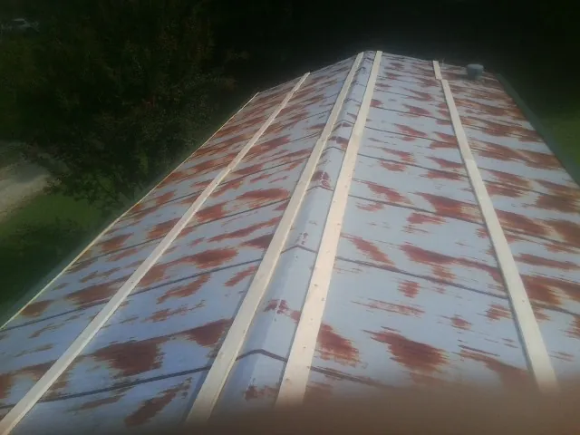 Rusted metal roof panels with new wood purlins before replacement — Storm Damage Roof Repair in Grasonville by Roofing Brothers