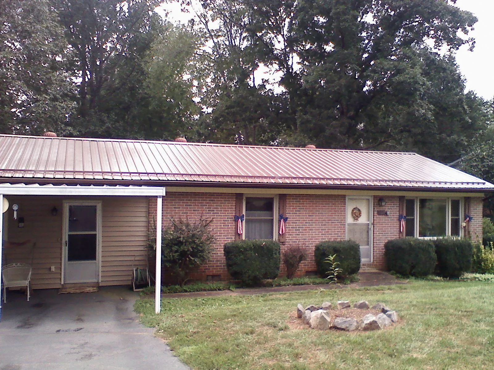 Bronze metal roof and carport on a brick ranch home — Roof Repair work by our crew in Grasonville